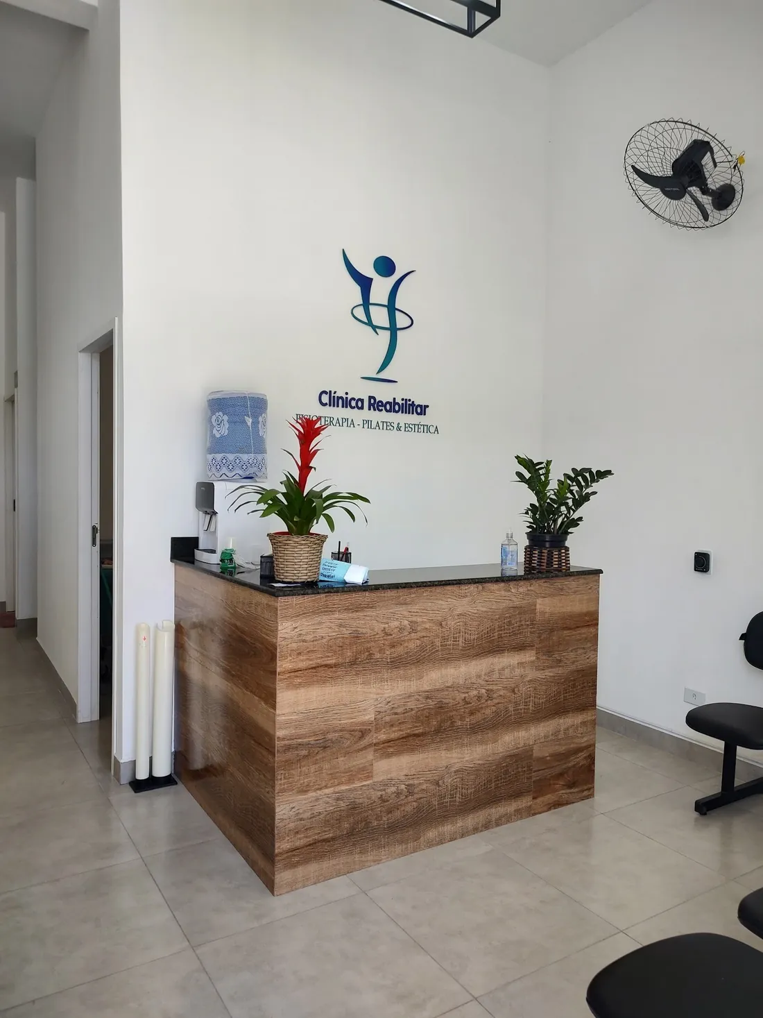 Recepção da Clínica Reabilitar com o logo na parede